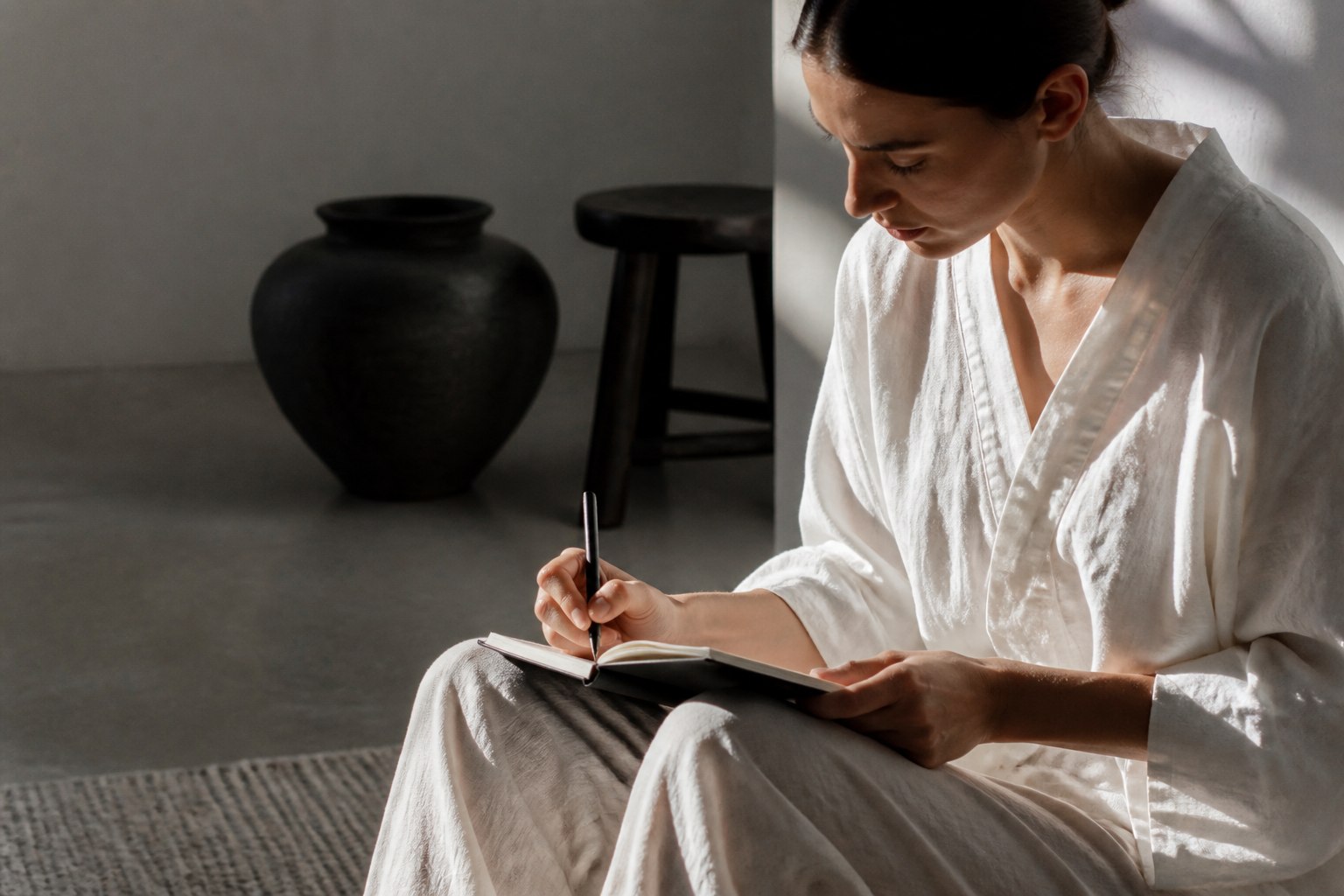 Person im Minimalismus Mode schreibt in ihrem Journal – Fokus und innere Ruhe
