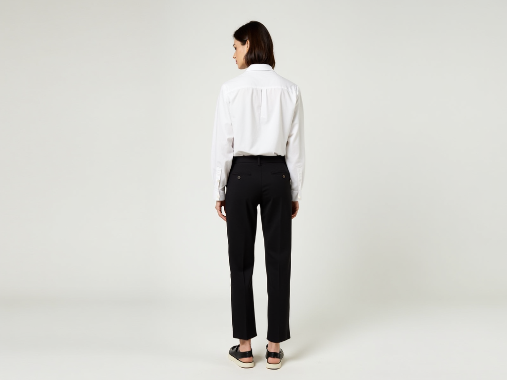 Person in minimalistischem Outfit mit weißem Hemd